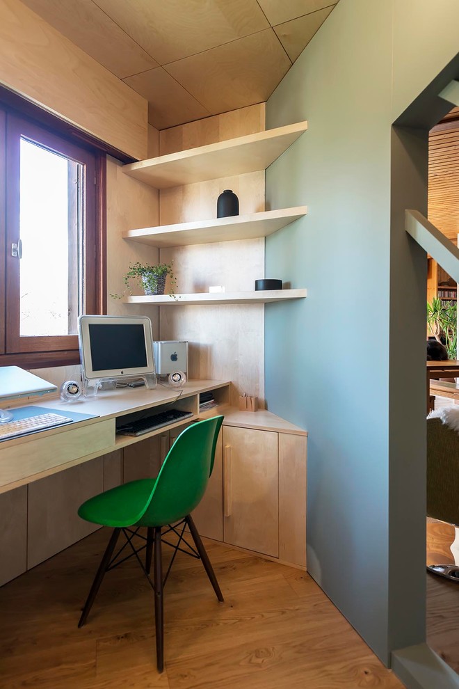 Inspiration pour un bureau design de taille moyenne avec un sol en bois brun, aucune cheminée, un bureau intégré et un mur gris.