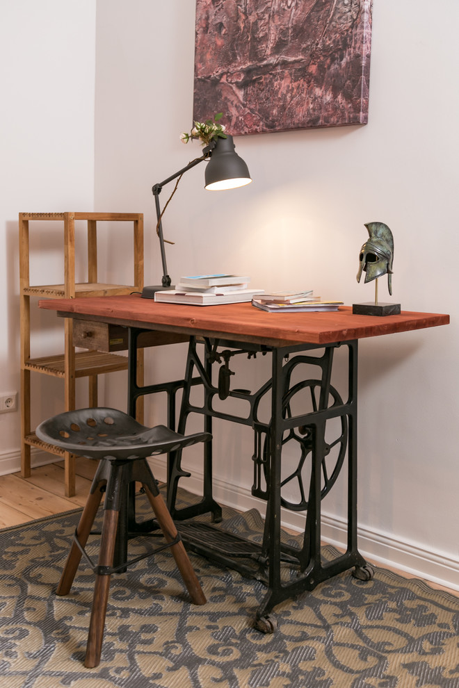 Diseño de despacho urbano pequeño sin chimenea con paredes blancas, suelo de madera en tonos medios, escritorio independiente y suelo marrón