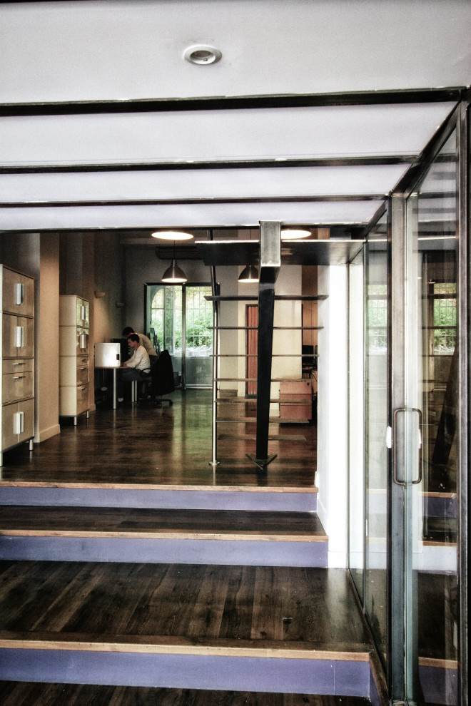 Cette photo montre un bureau industriel de taille moyenne avec un sol en bois brun, aucune cheminée et un bureau indépendant.