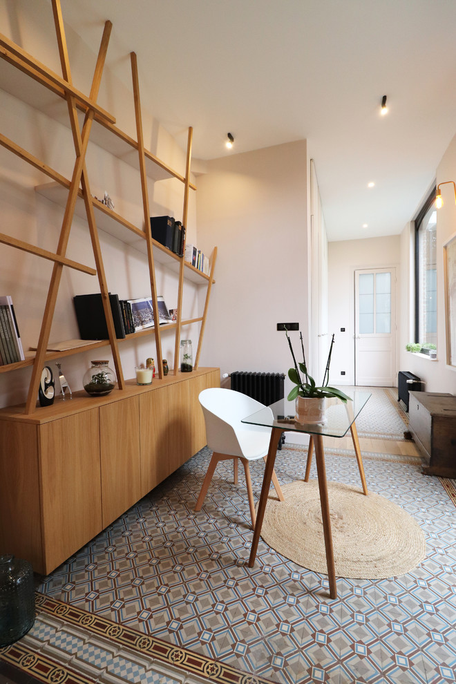 Стильный дизайн: рабочее место среднего размера в современном стиле с розовыми стенами, полом из терракотовой плитки, отдельно стоящим рабочим столом и синим полом - последний тренд
