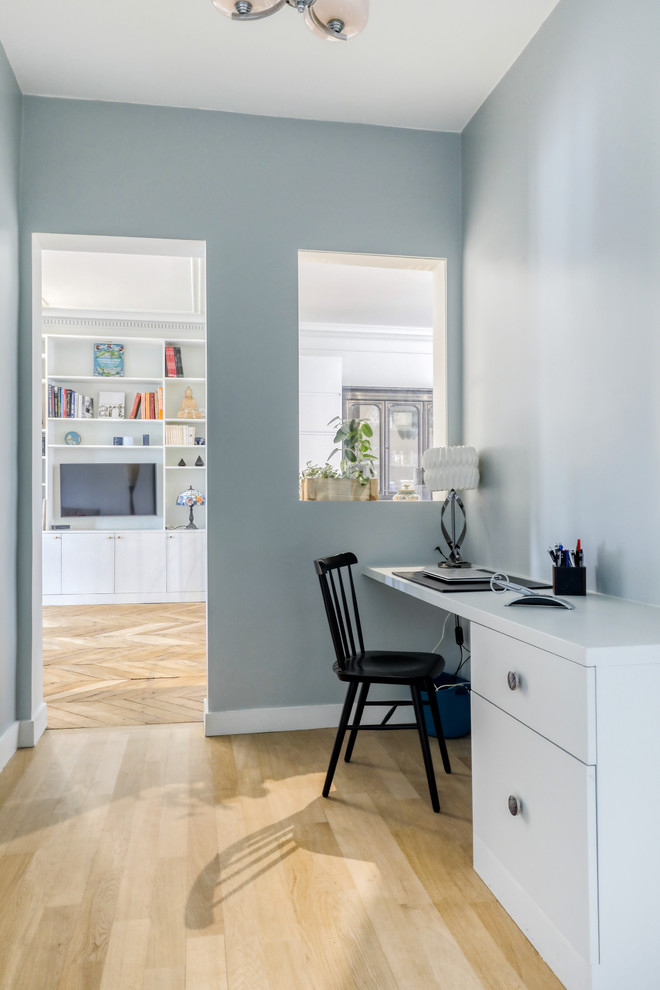 Inspiration for a medium sized contemporary home office in Paris with blue walls, light hardwood flooring, a built-in desk and beige floors.