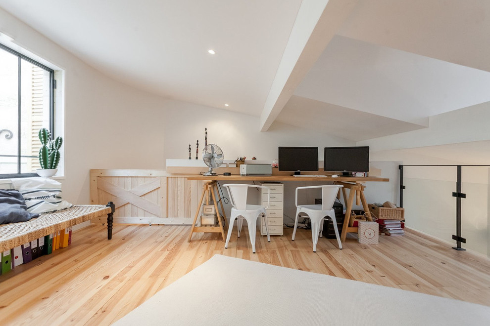 Ejemplo de despacho tradicional renovado grande sin chimenea con paredes blancas, suelo de madera clara y escritorio independiente