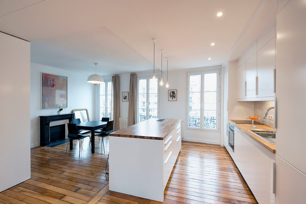 Immagine di una cucina minimal di medie dimensioni con pavimento in legno massello medio