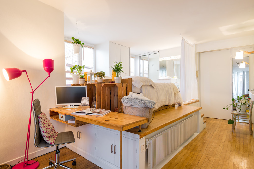 Imagen de despacho escandinavo pequeño con paredes blancas, suelo de madera en tonos medios y escritorio empotrado