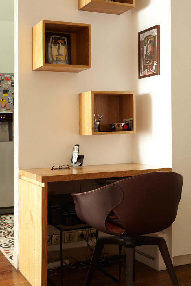 Ejemplo de despacho bohemio pequeño con paredes blancas, suelo de madera en tonos medios y escritorio empotrado