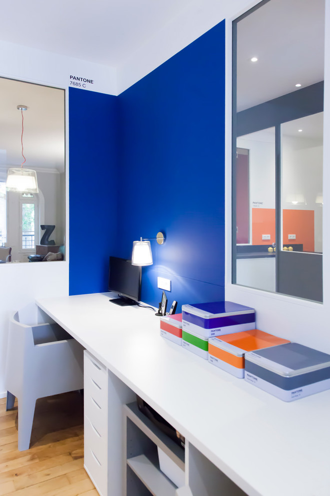 Inspiration för ett mellanstort funkis hemmabibliotek, med blå väggar, mellanmörkt trägolv och ett inbyggt skrivbord