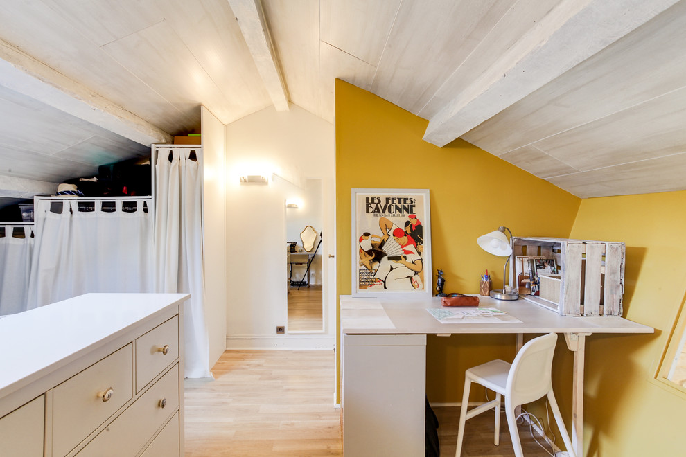 Immagine di un grande ufficio mediterraneo con pareti gialle, pavimento in laminato, scrivania incassata, nessun camino e pavimento beige