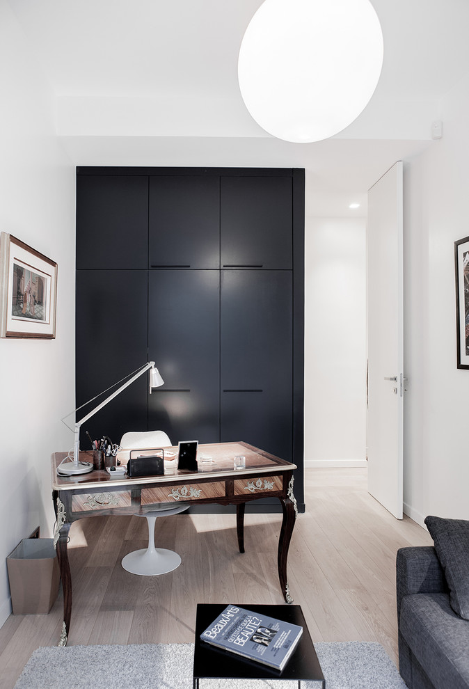 Imagen de despacho tradicional renovado de tamaño medio sin chimenea con paredes blancas, suelo de madera clara y escritorio independiente