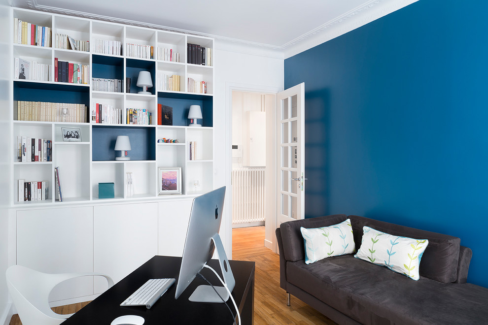 Idee per un ufficio chic di medie dimensioni con pareti blu, parquet chiaro, scrivania autoportante e pavimento beige