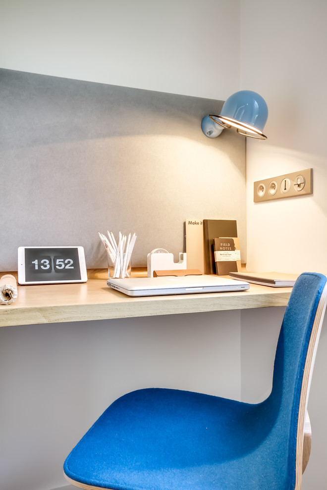 Exemple d'un petit bureau scandinave avec un mur blanc, un sol en bois brun, aucune cheminée, un bureau intégré et un sol marron.