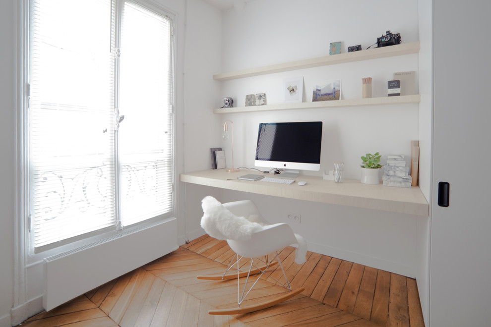 Inspiration för stora minimalistiska hemmabibliotek, med vita väggar, mellanmörkt trägolv, ett inbyggt skrivbord och brunt golv