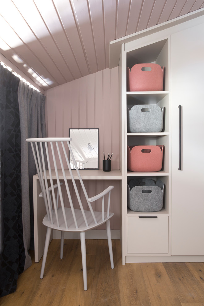 Idee per un piccolo ufficio moderno con pareti rosa, parquet chiaro, scrivania incassata e pavimento beige