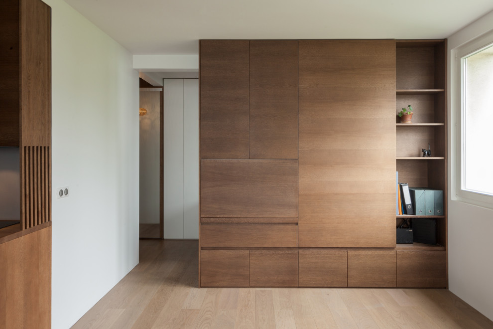 Cette photo montre un petit bureau tendance en bois avec un mur blanc, parquet clair, aucune cheminée et un bureau intégré.
