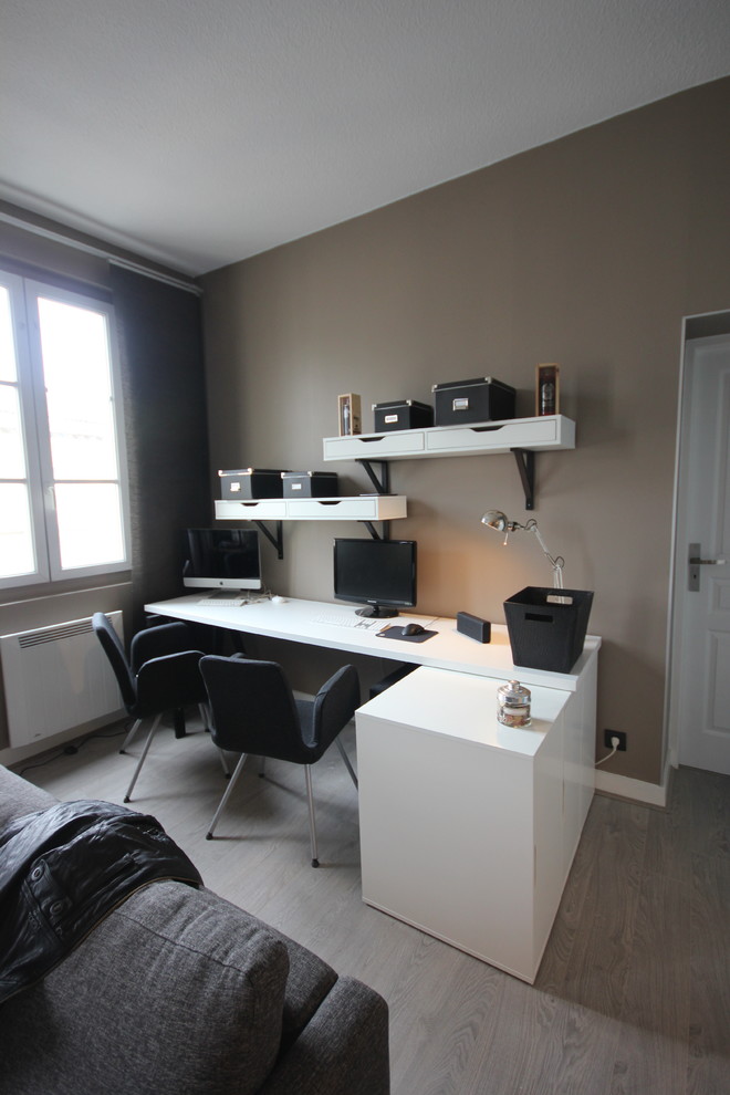 Idee per un piccolo atelier moderno con pareti beige, pavimento in laminato, scrivania autoportante e pavimento grigio