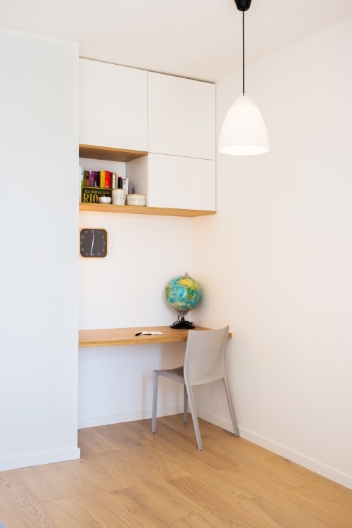 Kleines Modernes Arbeitszimmer ohne Kamin mit Arbeitsplatz, weißer Wandfarbe, braunem Holzboden und Einbau-Schreibtisch in Paris
