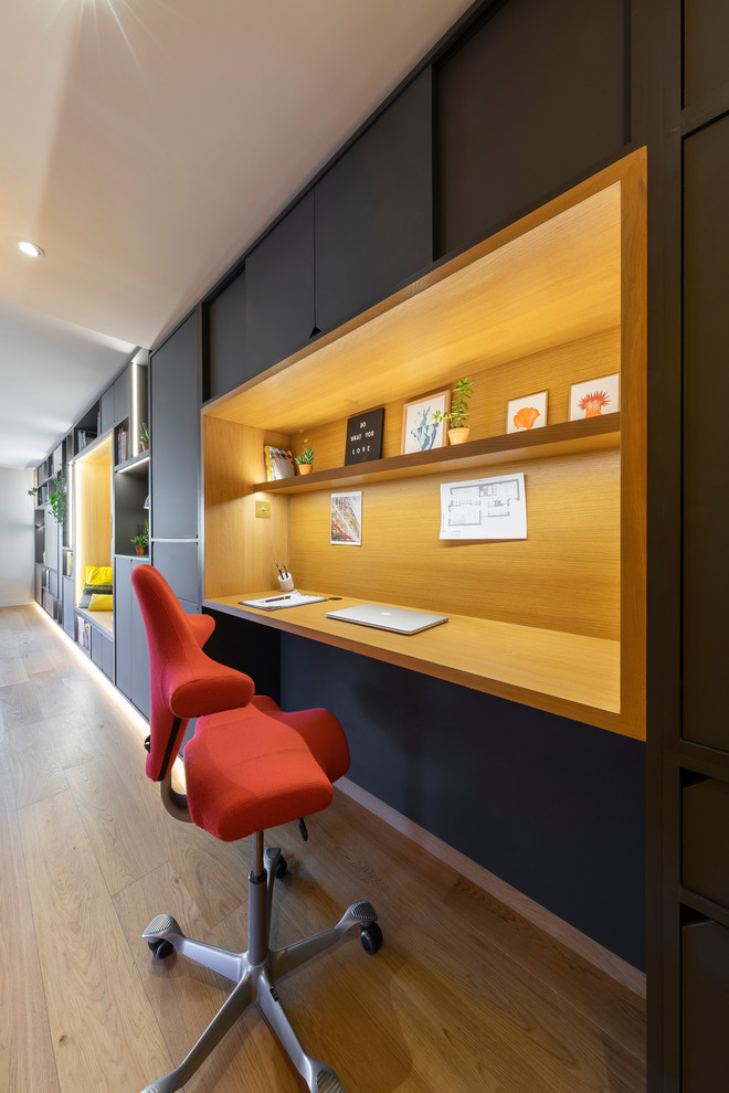 Ispirazione per un piccolo ufficio moderno con pareti grigie, parquet chiaro, nessun camino, scrivania incassata e pavimento marrone