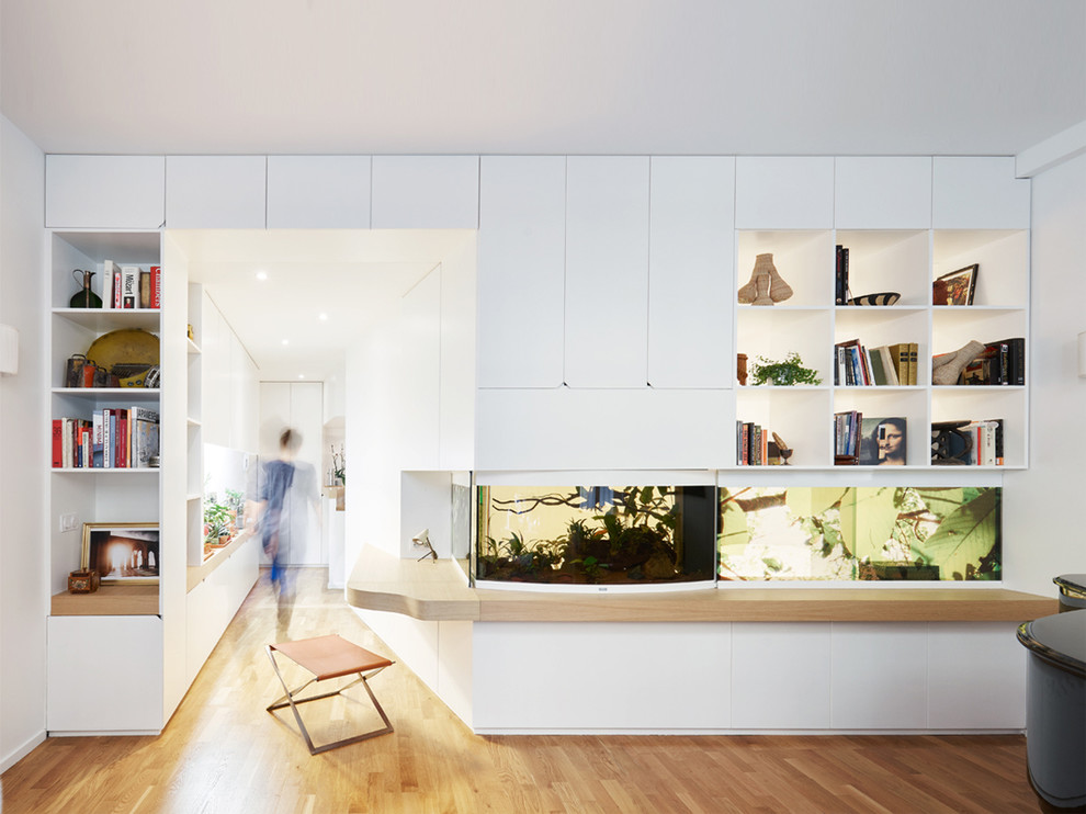 Mittelgroßes Modernes Lesezimmer ohne Kamin mit weißer Wandfarbe, hellem Holzboden und Einbau-Schreibtisch in Paris