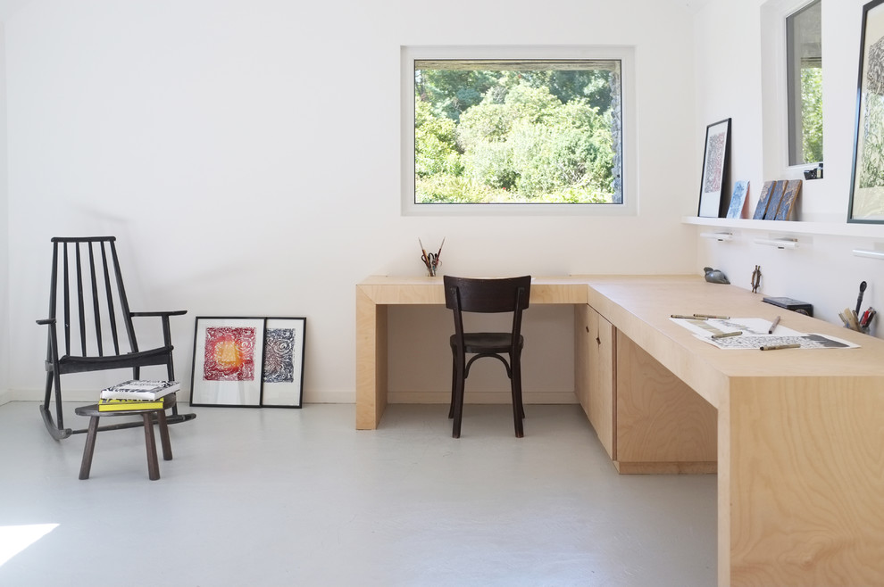 Bild på ett mellanstort minimalistiskt arbetsrum, med vita väggar och ett fristående skrivbord