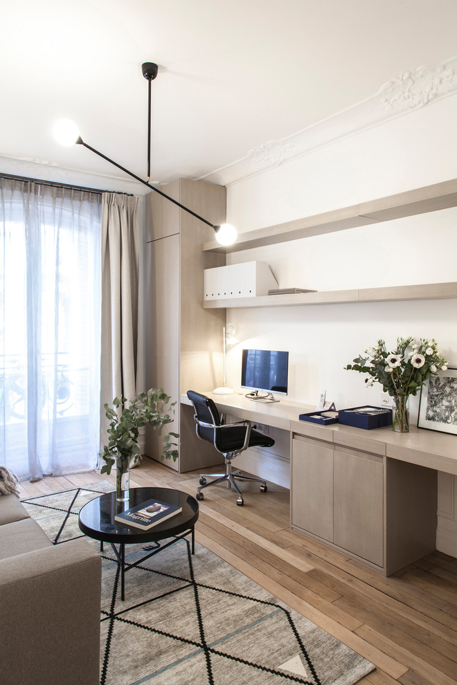 На фото: рабочее место в скандинавском стиле с белыми стенами, светлым паркетным полом и встроенным рабочим столом без камина