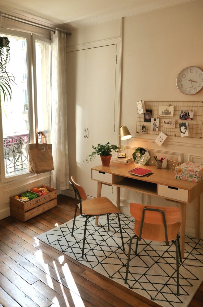 Mittelgroßes Nordisches Arbeitszimmer mit Arbeitsplatz, weißer Wandfarbe, braunem Holzboden und freistehendem Schreibtisch in Paris