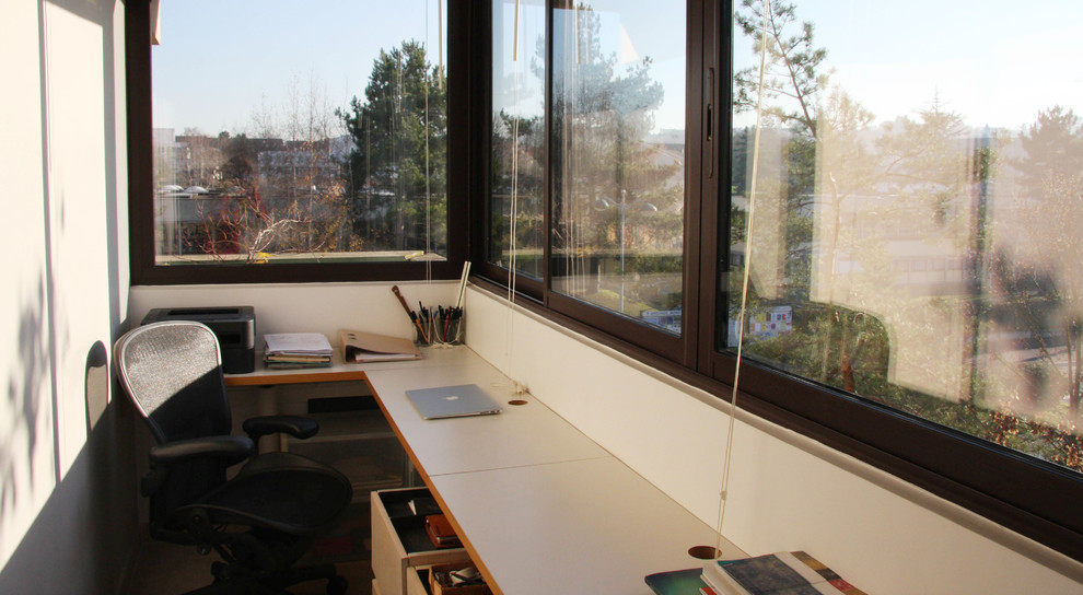 Immagine di un piccolo ufficio minimal con pavimento in pietra calcarea, scrivania incassata, pareti bianche e pavimento beige