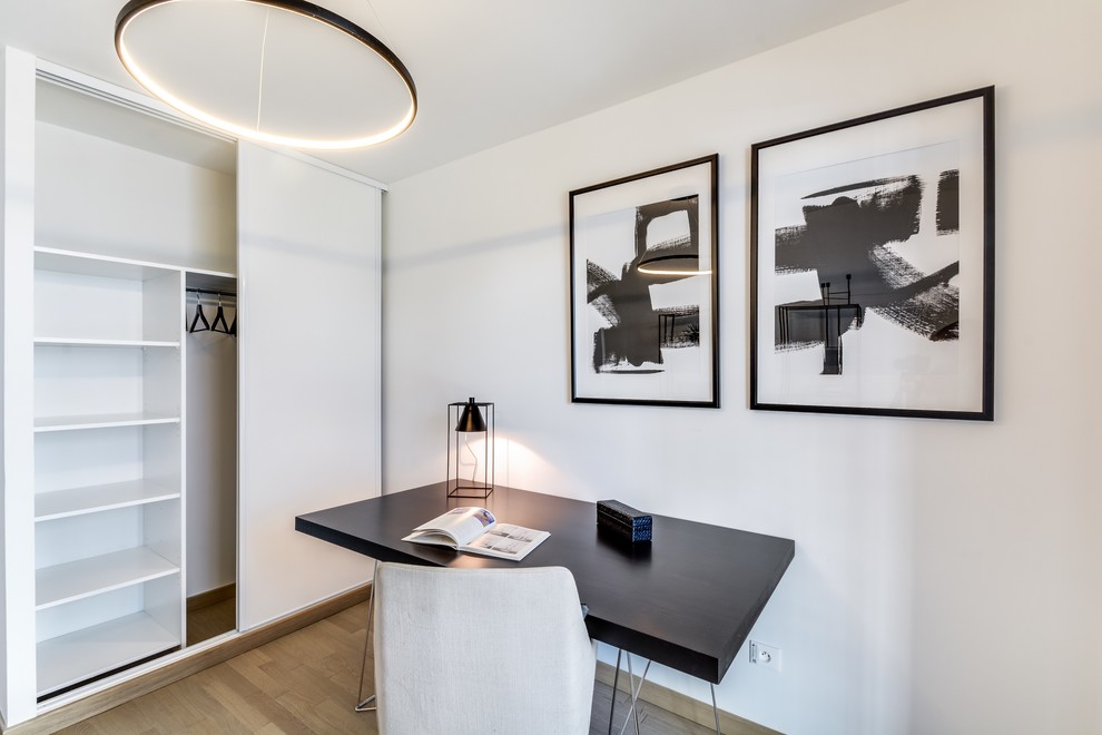 Mittelgroßes Modernes Arbeitszimmer ohne Kamin mit Arbeitsplatz, weißer Wandfarbe, hellem Holzboden und freistehendem Schreibtisch in Paris