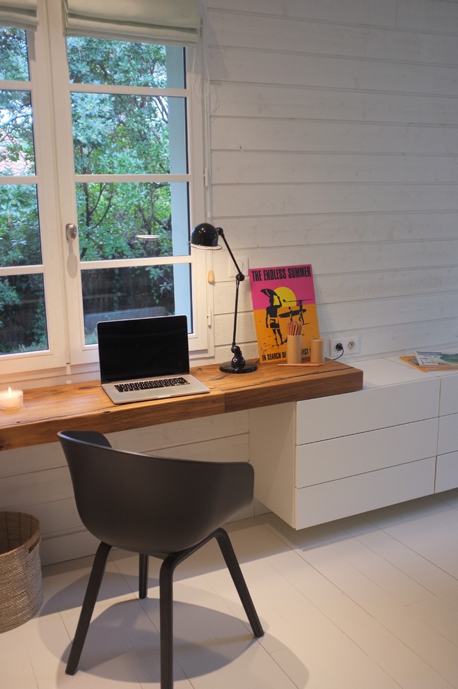 На фото: рабочее место в морском стиле с белыми стенами, деревянным полом и встроенным рабочим столом с