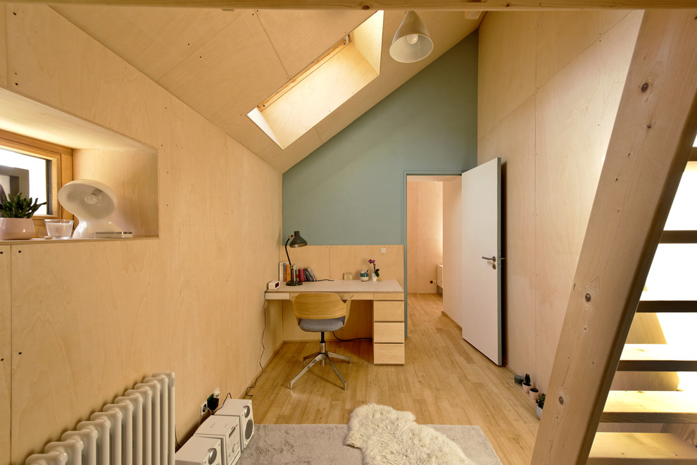 Réalisation d'un bureau design avec un mur vert, un sol en bois brun, un bureau intégré et un sol marron.
