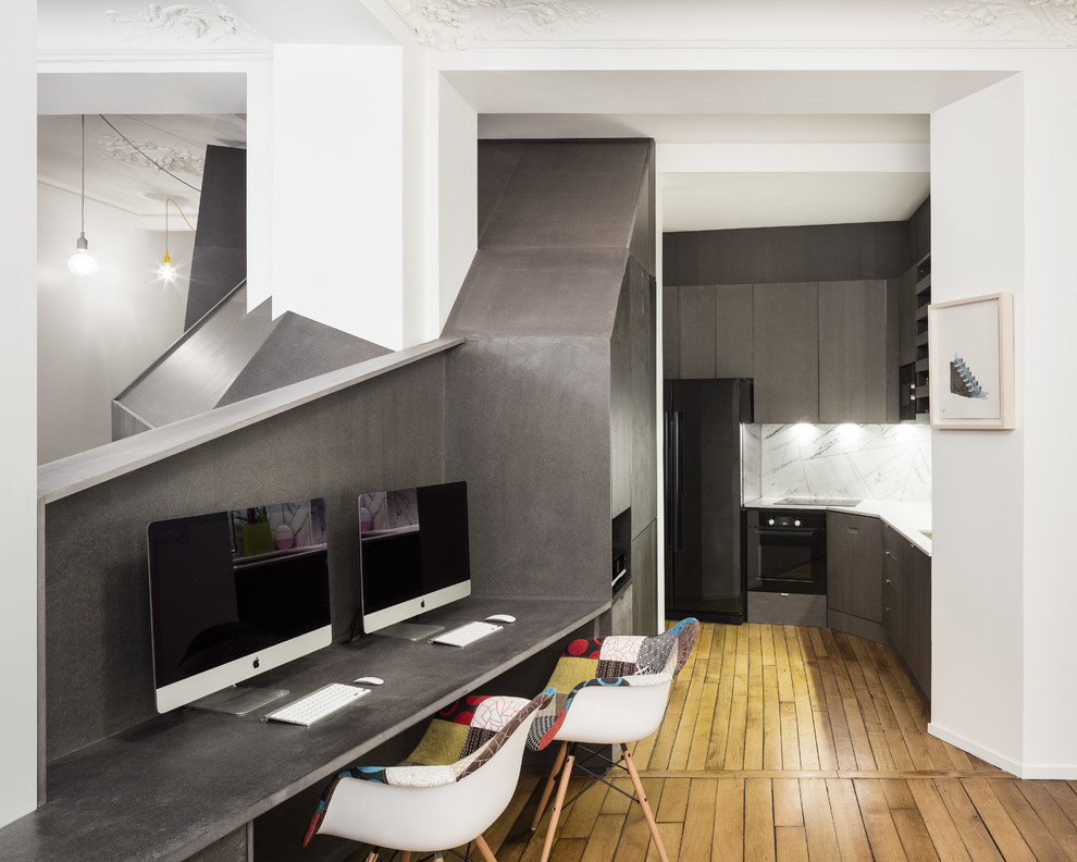 Idée de décoration pour un petit bureau design avec un sol en bois brun, un bureau intégré, un mur noir et aucune cheminée.