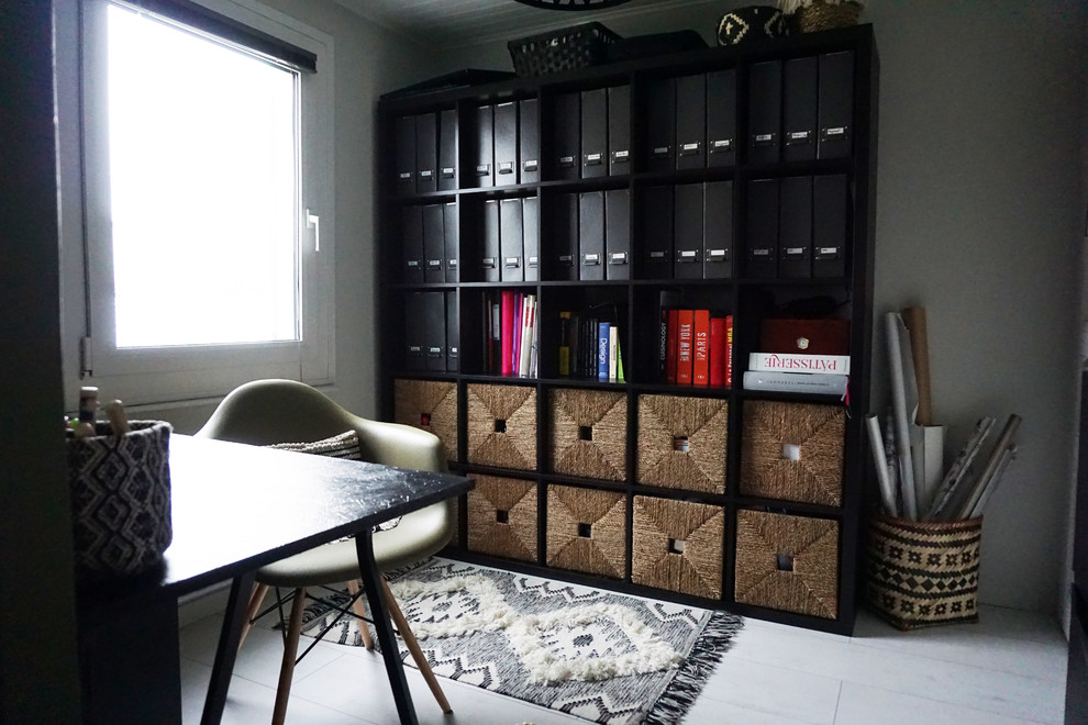 Bild på ett litet funkis arbetsrum, med ett bibliotek, gröna väggar, laminatgolv, ett fristående skrivbord och vitt golv