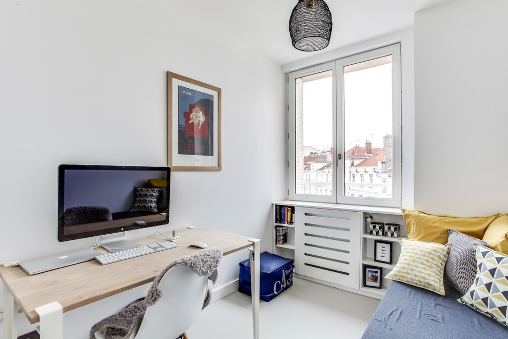 This is an example of a small scandinavian home office in Lyon with a reading nook, white walls and concrete flooring.