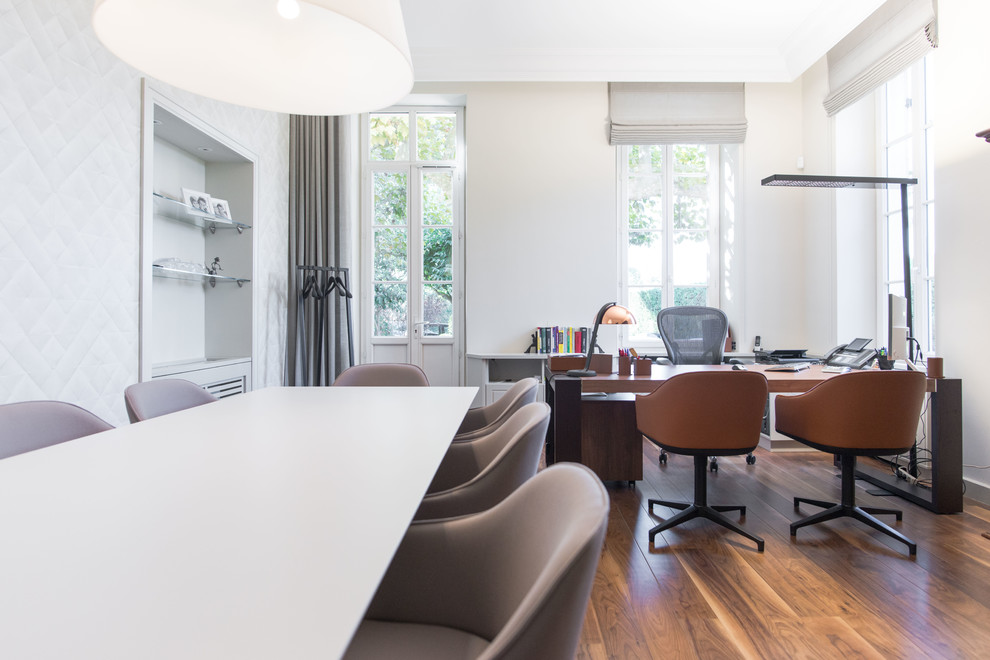 Foto di un grande ufficio minimal con pareti beige e pavimento in legno massello medio