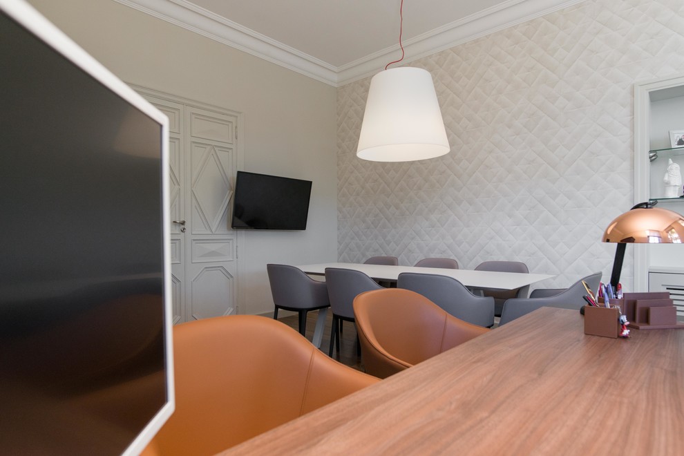 Cette image montre un grand bureau design avec un mur beige et un sol en bois brun.