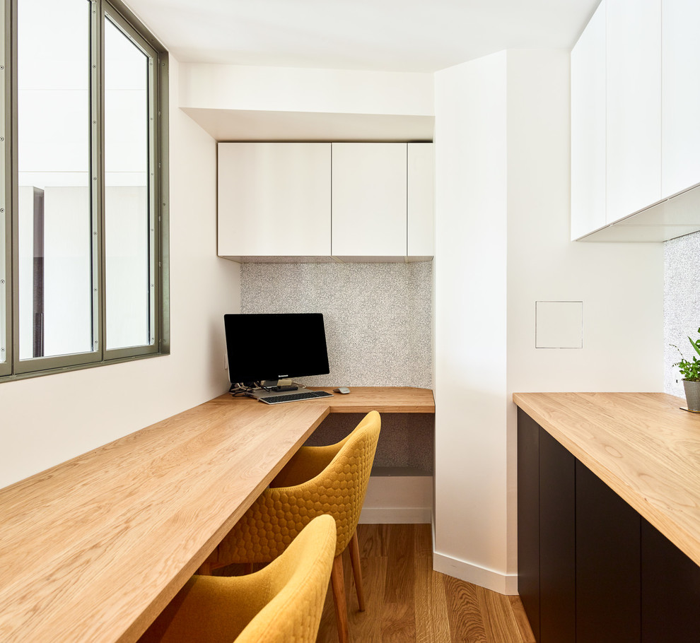 Exemple d'un grand bureau tendance avec un mur blanc, parquet clair, un bureau indépendant et un sol marron.