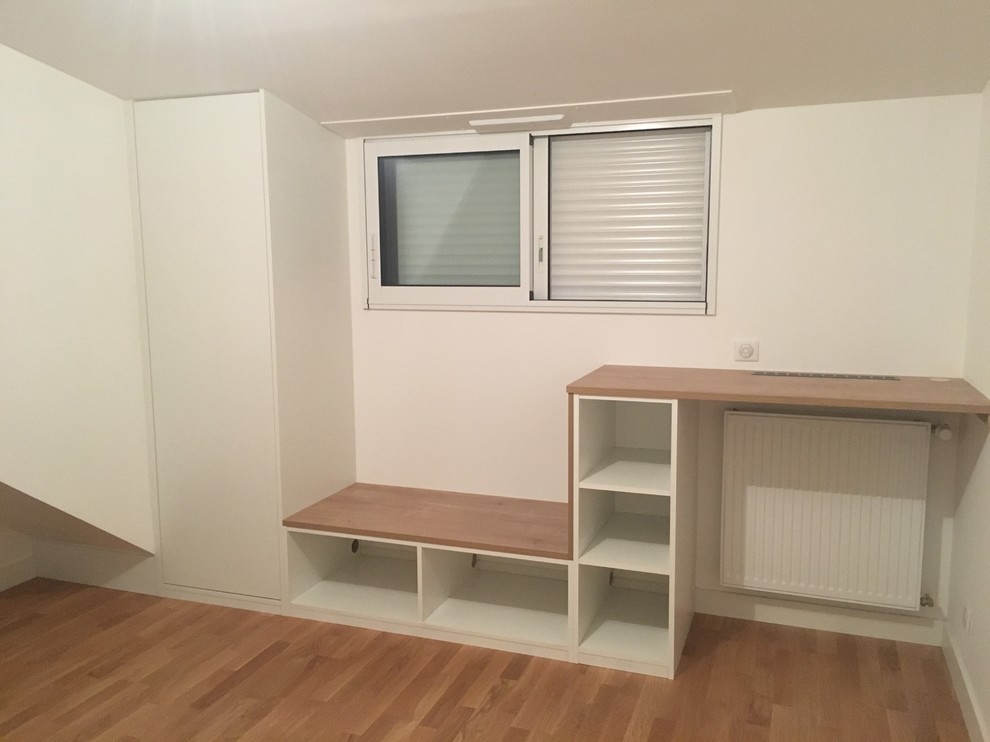 Kleines Modernes Arbeitszimmer ohne Kamin mit Arbeitsplatz, weißer Wandfarbe, Laminat, Einbau-Schreibtisch und braunem Boden in Nantes