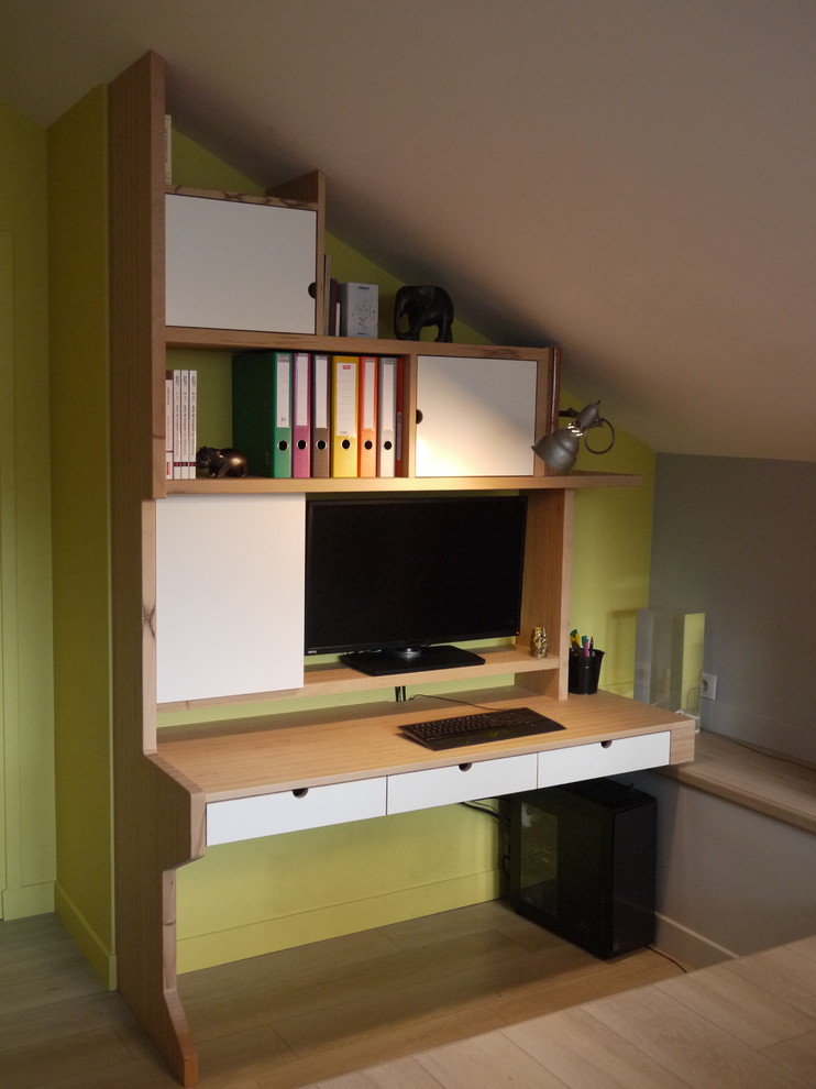 Esempio di un ufficio minimalista con pareti gialle, parquet chiaro e scrivania autoportante