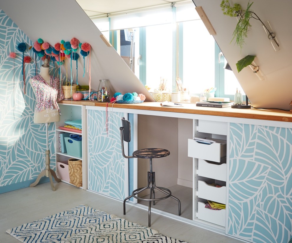 Cette photo montre un bureau atelier tendance de taille moyenne avec un mur bleu, parquet clair, aucune cheminée, un bureau intégré et un sol beige.