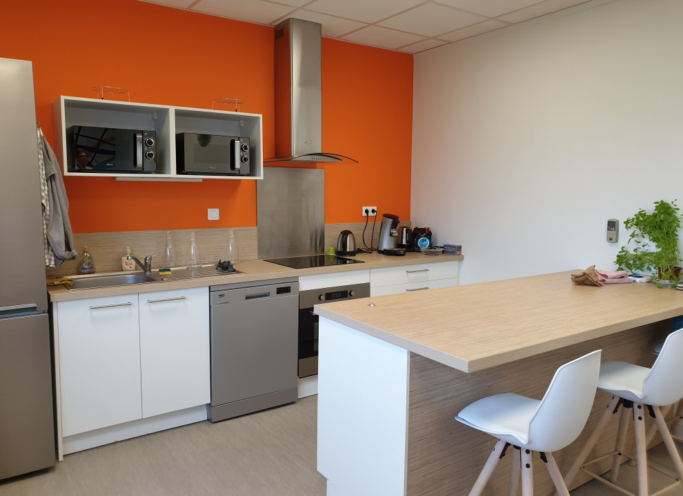Стильный дизайн: рабочее место среднего размера в стиле модернизм с оранжевыми стенами, полом из винила, отдельно стоящим рабочим столом и бежевым полом - последний тренд