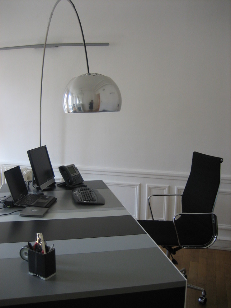 Идея дизайна: рабочее место среднего размера в современном стиле с белыми стенами, светлым паркетным полом, отдельно стоящим рабочим столом и коричневым полом без камина