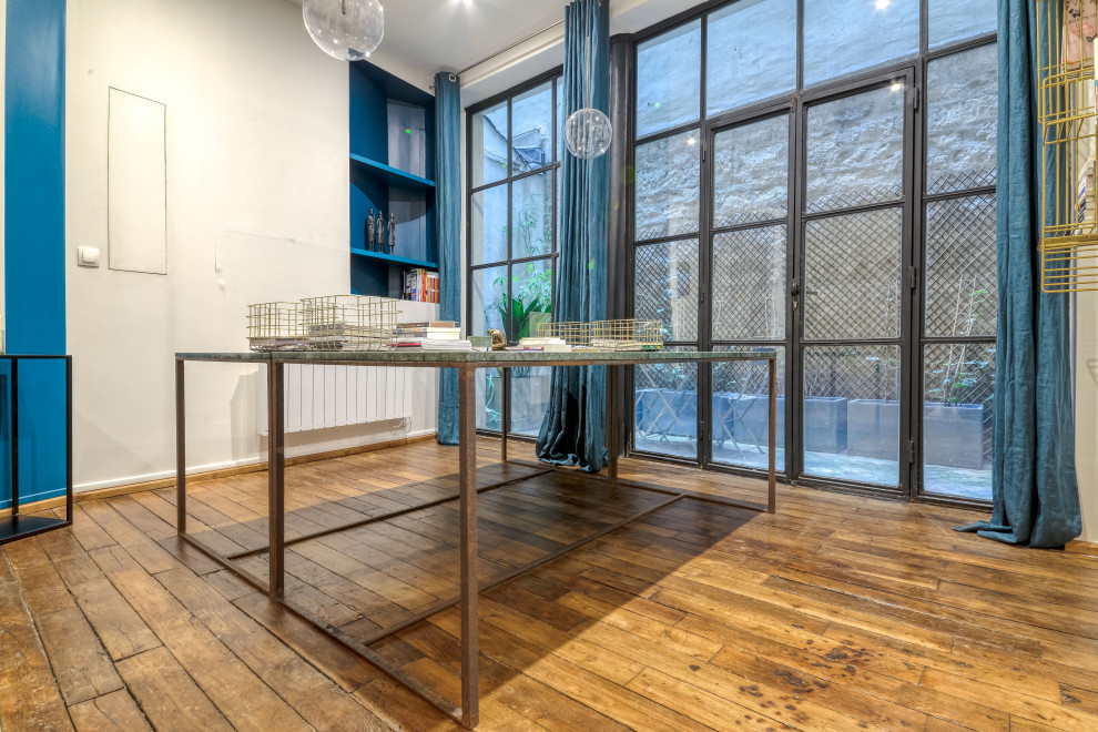 Réalisation d'un bureau design de taille moyenne avec un sol en bois brun, un bureau indépendant, un mur bleu et un sol marron.