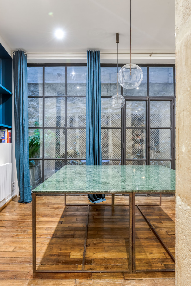 Aménagement d'un bureau contemporain de taille moyenne avec un sol en bois brun, un bureau indépendant, un mur bleu et un sol marron.