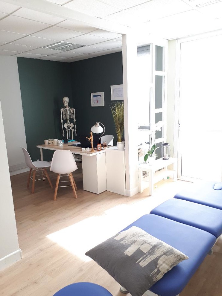 Diseño de despacho nórdico de tamaño medio con paredes verdes, suelo vinílico y escritorio independiente
