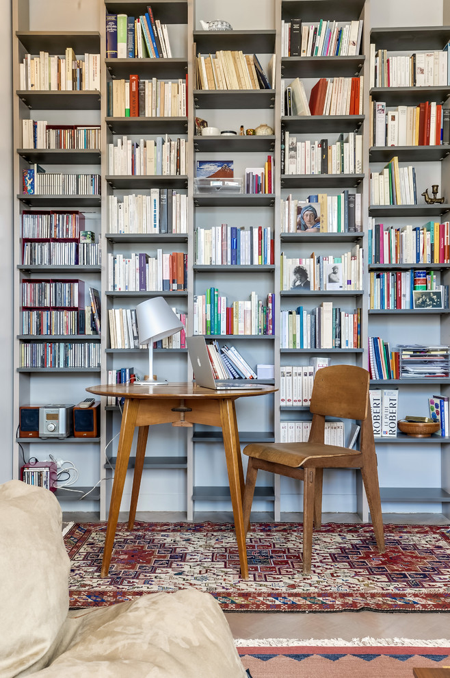 パリにある高級な中くらいなトランジショナルスタイルのおしゃれな書斎 (グレーの壁、無垢フローリング、暖炉なし、自立型机) の写真