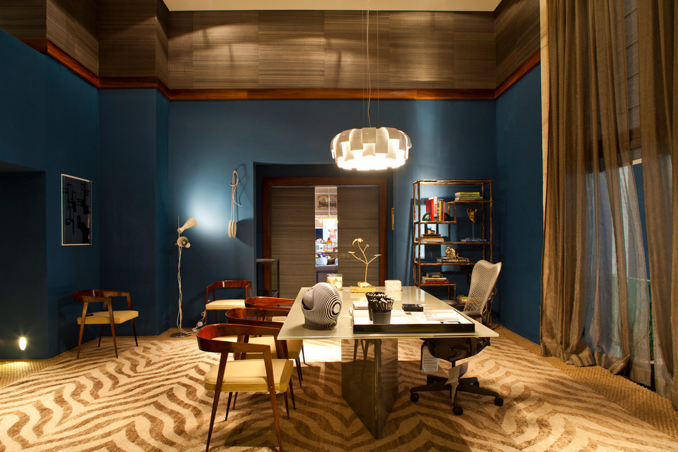 Inspiration för ett stort tropiskt hemmabibliotek, med blå väggar, heltäckningsmatta och ett fristående skrivbord
