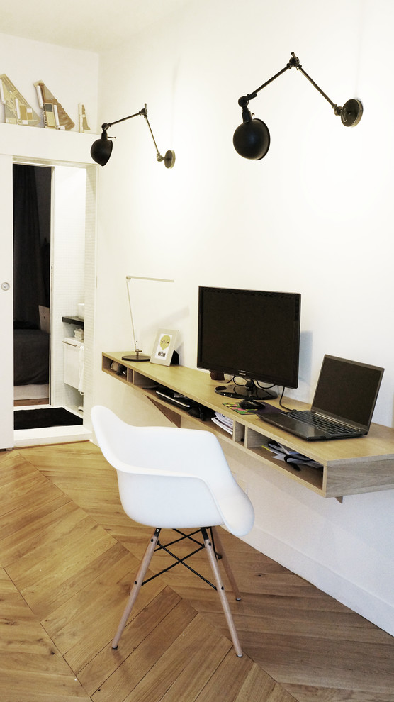 Ejemplo de despacho contemporáneo de tamaño medio sin chimenea con paredes blancas, suelo de madera clara y escritorio empotrado