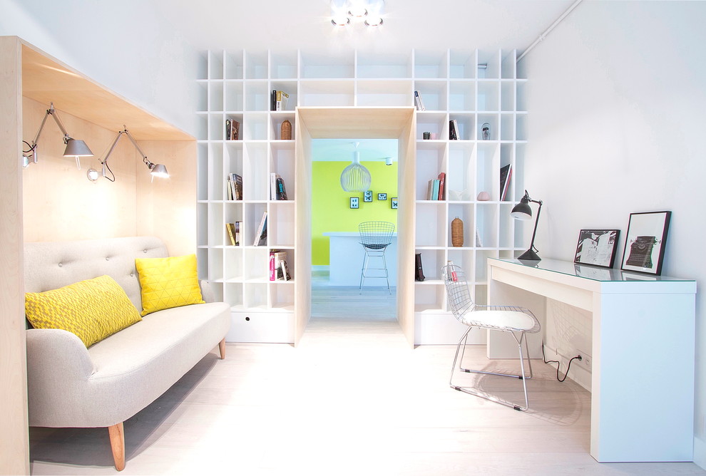 Diseño de despacho nórdico grande con paredes blancas, escritorio independiente y suelo de madera clara