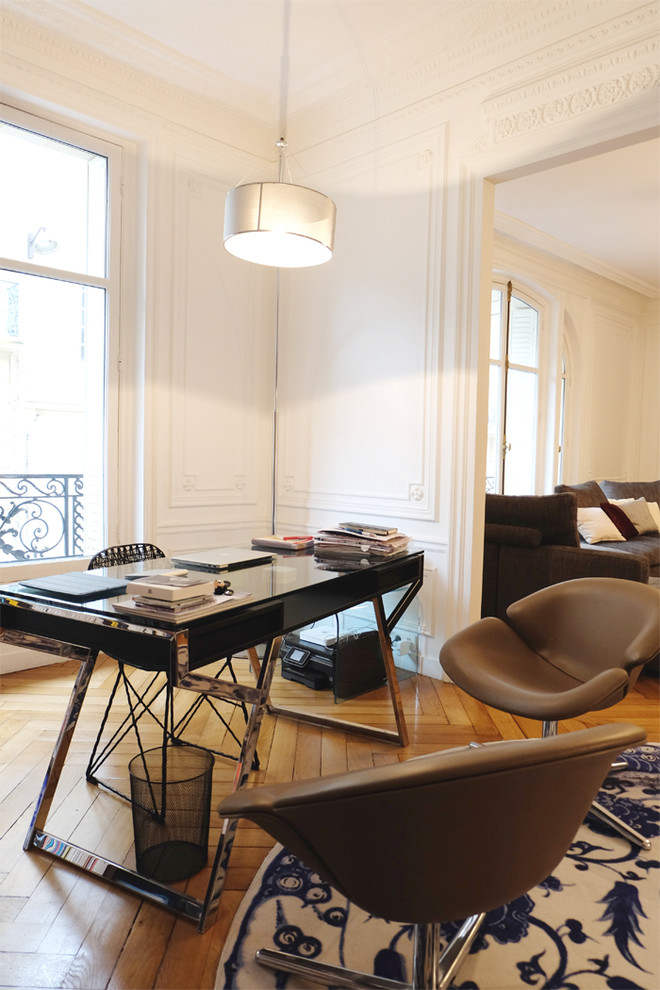 Medium sized contemporary study in Paris with white walls, medium hardwood flooring and a freestanding desk.