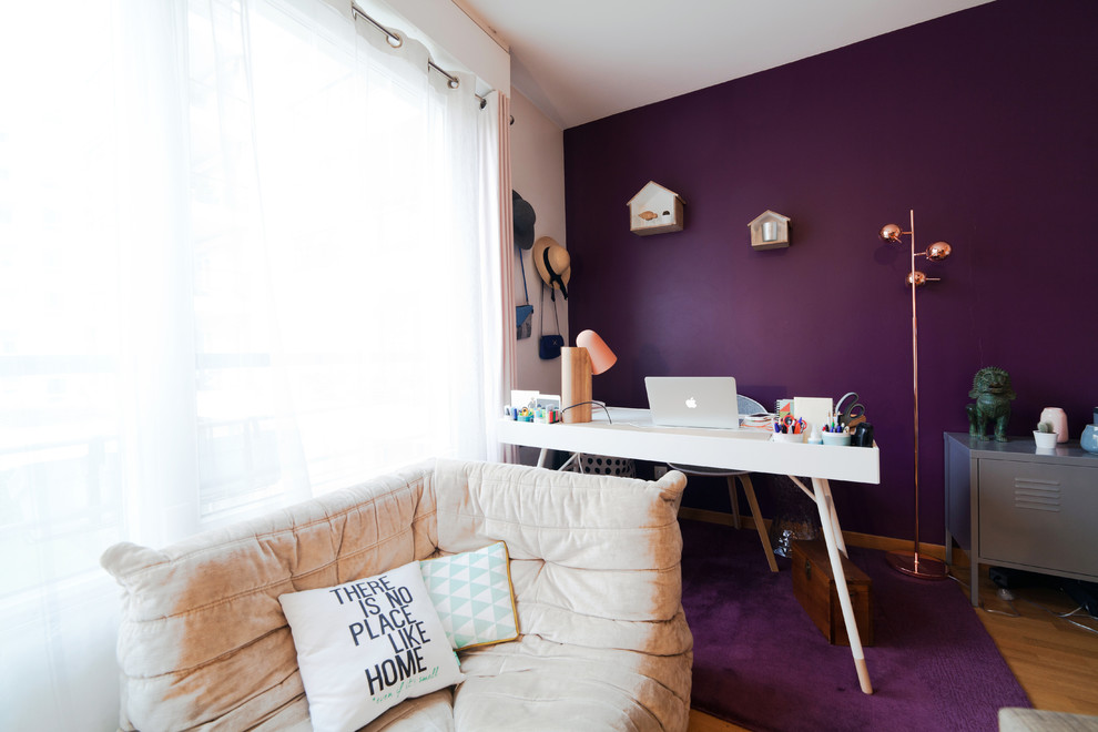 Kleines Modernes Arbeitszimmer ohne Kamin mit Arbeitsplatz, lila Wandfarbe, braunem Holzboden und freistehendem Schreibtisch in Paris