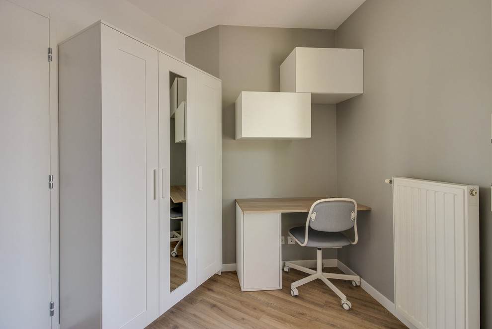 Idée de décoration pour un bureau nordique avec un mur gris, un sol en bois brun, un bureau intégré et un sol marron.