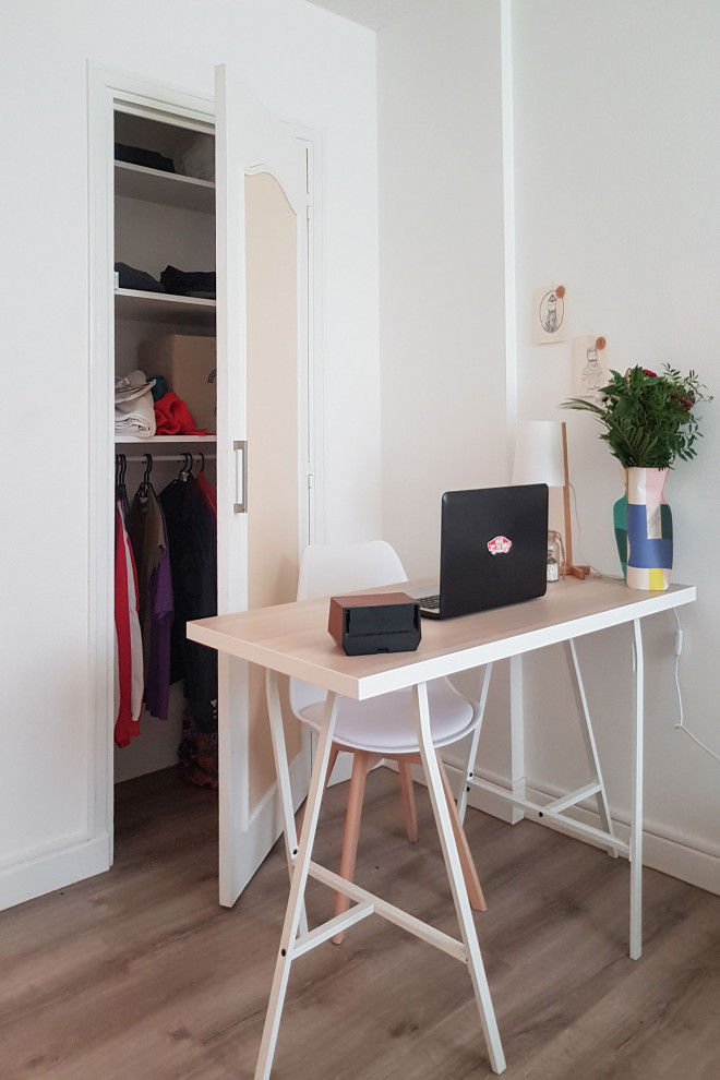 Esempio di un piccolo ufficio nordico con pareti bianche, pavimento beige, pavimento in laminato e scrivania autoportante